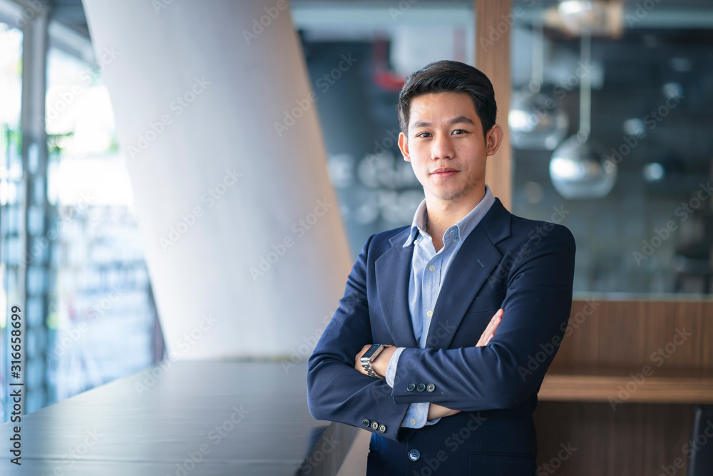 Asian confident businessman arms crossed in the working space. Asian confident businessman arms crossed in the working space.