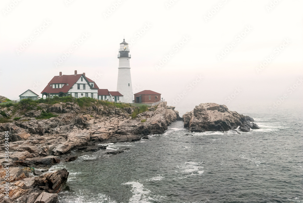 The Portland Head Lighthouse, located on the coast of Maine, in the fog.