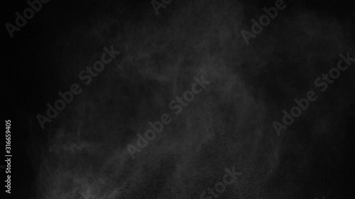 white vapour or spray water on a black background ,slow motion movement photo