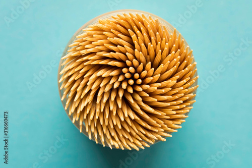 Lots of wooden toothpicks on a blue background. Abstract background for the design. The view from the top.
