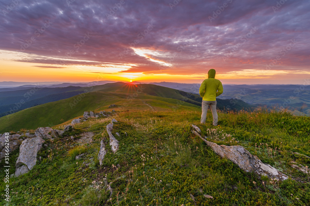 Adorable autumn landscapes in Carpathian mountains with beautiful tourist girl traveling with red tent