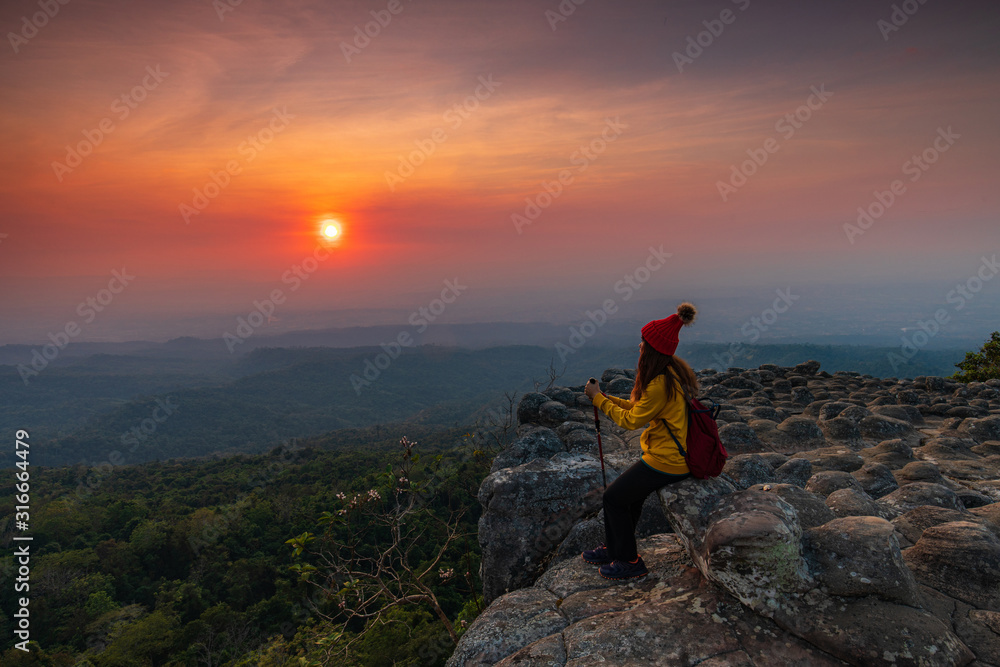 Fototapeta premium Young woman hiking on mountains. Lan-hin-pum, Phu Hin Rong Kla National park, Phitsanulok province , Thailand.