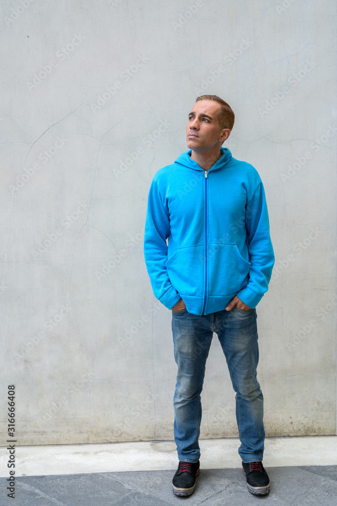 Portrait of mature Persian man wearing hoodie outdoors