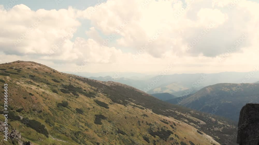 Green grassy meadow on hillside of mountain ridge. Beautiful summer landscape in Carpathian mountains. Green grassy meadow on hillside of mountain ridge. Beautiful summer landscape in Carpathian mountains.