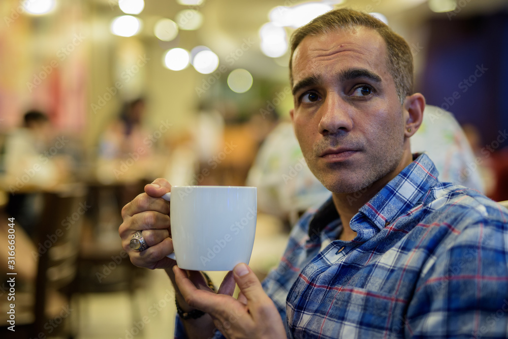 Mature Persian man relaxing inside the coffee shop Mature Persian man relaxing inside the coffee shop