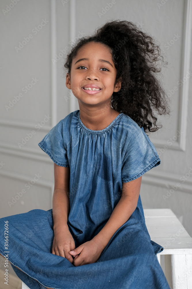 The African American child looks directly into the camera in the children's room. The African American child looks directly into the camera in the children's room.
