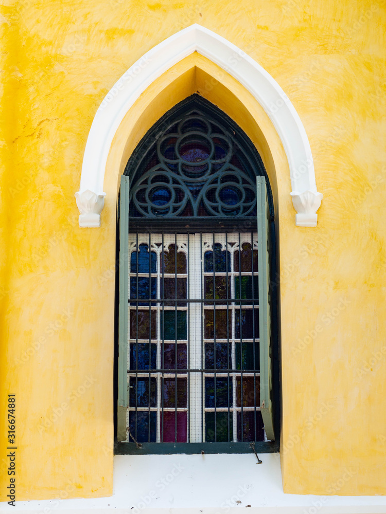Obraz premium Window Thai architecture is influenced by Europe,Yellow wall And Green door Unique pattern of Thailand,Texture wall color Stain