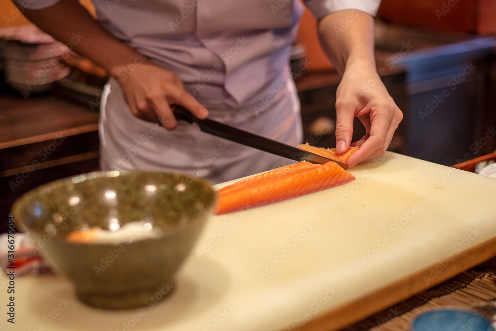 Obraz premium Japanese chef hand on cutting salmon prepare for making Donburi Salmon