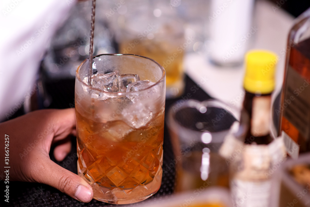 Bartender making whiskey cocktail Bartender making whiskey cocktail