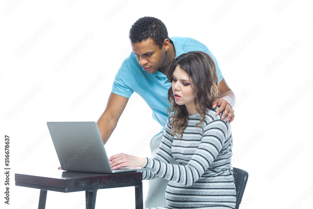 Portrait of a lovely young pregnant couple sitting on a couch with laptop computer. Black man and white woman. Portrait of a lovely young pregnant couple sitting on a couch with laptop computer. Black man and white woman.