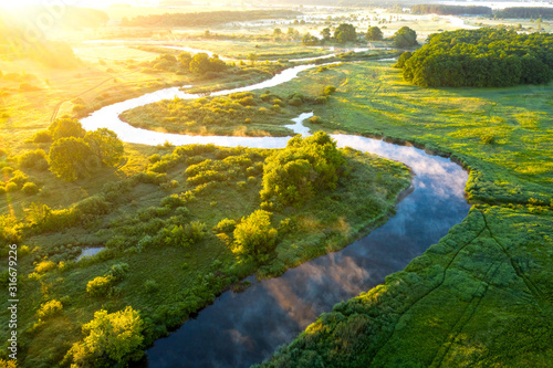 Aerial view of beautiful landscape of foggy river and green fields. Sunrise over river in summer © dzmitrock87