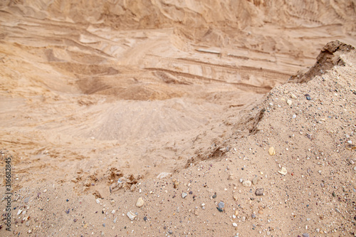 Dangerous edge of the sand quarry and steep cliff down. Quarrying and mining of building material.