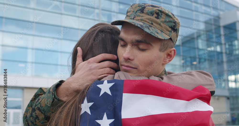 Soldier hugging girl covered with american flag. Soldier hugging girl covered with american flag.