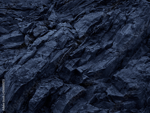 Toned mountain texture. Detail. Blue stone background. Dark blue grunge background. Deep blue rock stones background. Close-up. Abstract black background.