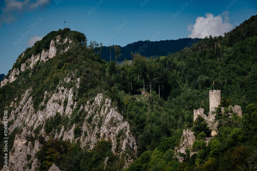 romantic castle on top of a hill in a mountainous valley