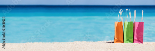 Photography Shopping bags on sand against turquoise caribbean sea water
