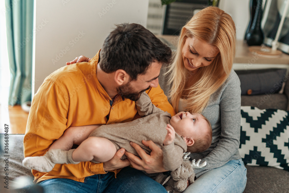 Happy mother and father with baby at home Happy mother and father with baby at home