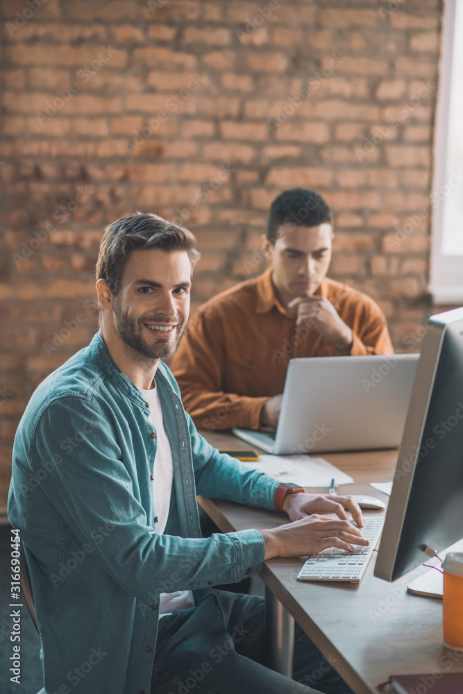 Cheerful smart man sitting in front of his computer Cheerful smart man sitting in front of his computer