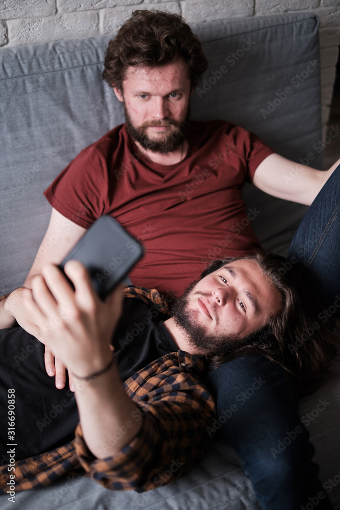 Fototapeta premium Two men taking selfie on the sofa