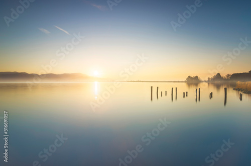 Wooden pier or jetty remains and lake at sunrise. Torre del lago Puccini Versilia Tuscany, Italy