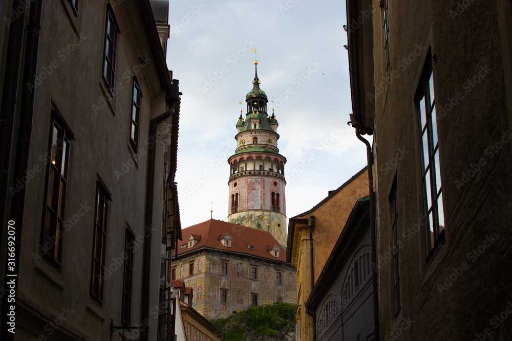 Castle Tower, the most famous symbol of Cesky Krumlov, in State Castle, viewed between some buildings (Czech Republic)