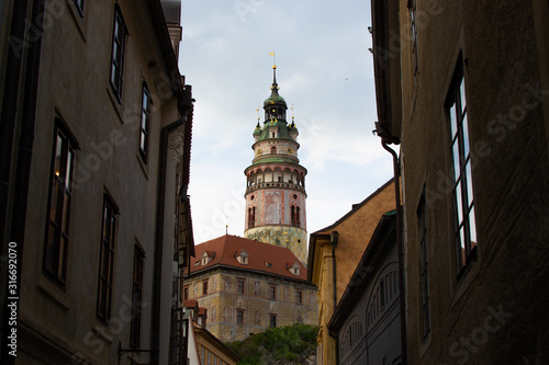 Castle Tower, the most famous symbol of Cesky Krumlov, in State Castle, viewed between some buildings (Czech Republic)