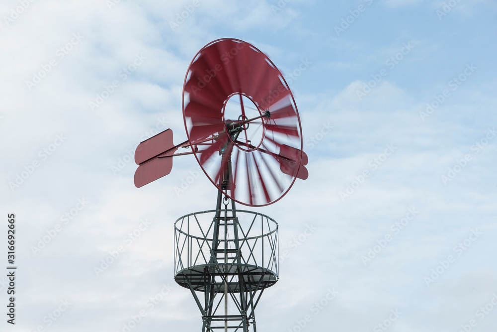Old red windmill spinning.
