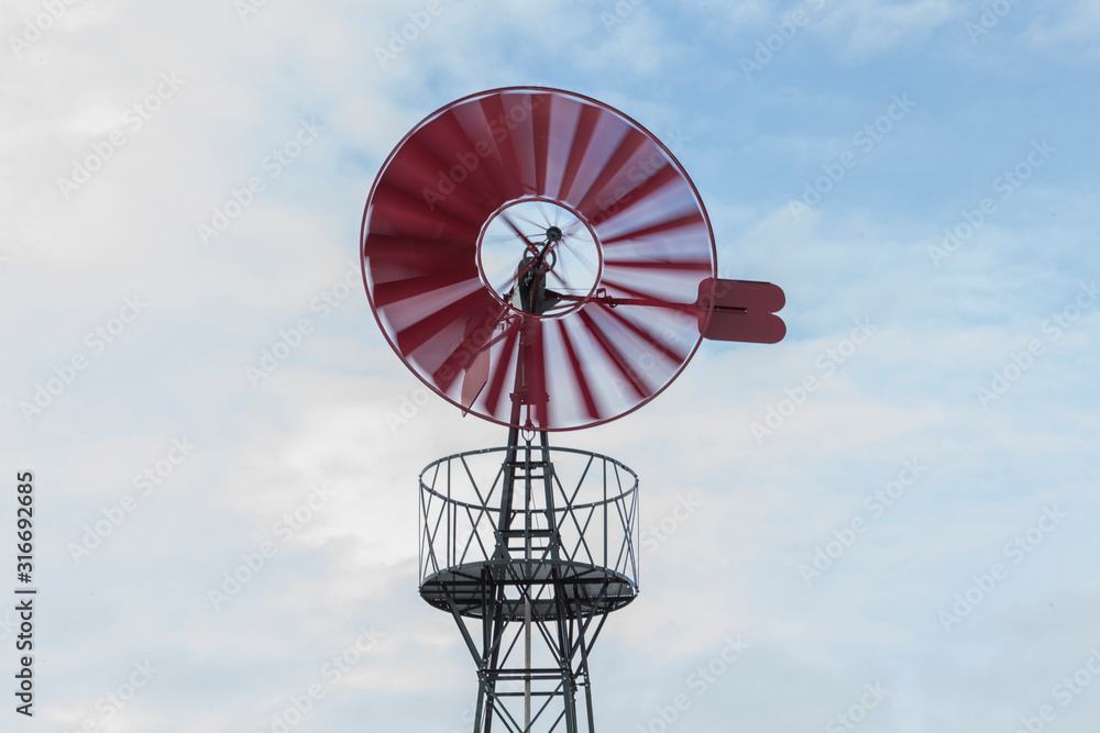 Old red windmill spinning.