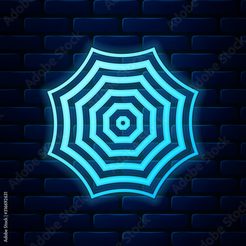 Glowing neon Sun protective umbrella fo beach icon isolated on brick wall background. Large parasol for outdoor space. Beach umbrella. Summer vacation or picnic accessory. Vector Illustration