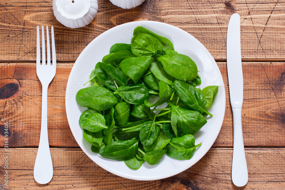 Step by step preparation of spinach salad with egg and cheese, step 2 - cleaning washing spinach for salad, top view, selective focus Step by step preparation of spinach salad with egg and cheese, step 2 - cleaning washing spinach for salad, top view, selective focus