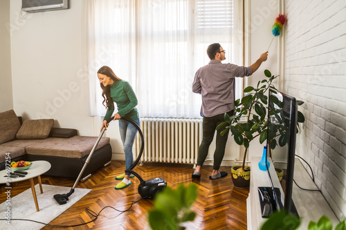 Photography Young happy couple is cleaning their apartment.