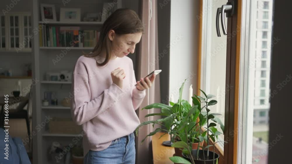 Young cute woman taking photos of home flowers and plants on smartphone. 4k Young cute woman taking photos of home flowers and plants on smartphone. 4k