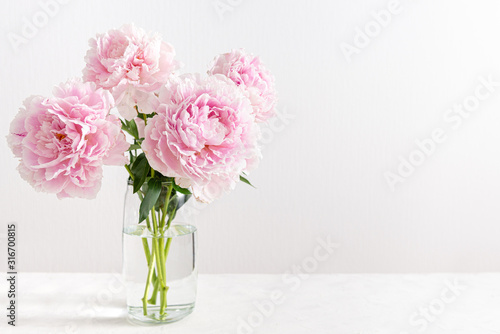Lovely flowers in glass vase. Beautiful bouquet of pink peonies. Floral composition, copy space. Wallpaper, greeting card, poster, floral shop concept