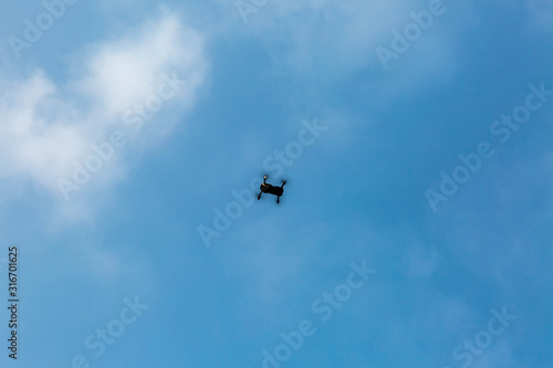 quadrocopter in the blue sky with clouds