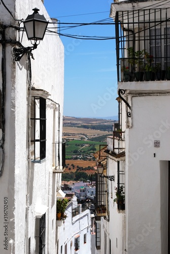 View down narrow street towards countryside, Arcos de la Fronter, Spain. photo
