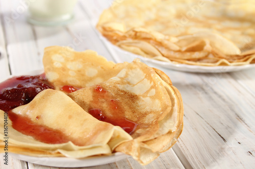 Thin pancakes with strawberry jam