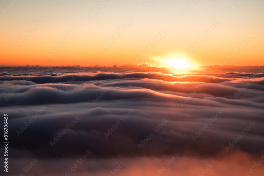Winter landscape in Krkonose, beautiful sunrise with moon above the heavy clouds, shot from highest mountain in Czech republic called Snezka.