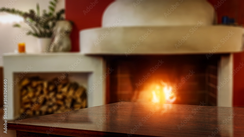 Desk of free space for your decoration and blurred home interior with fireplace 