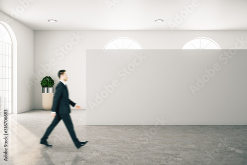 Businessman walking in contemporary gallery interior