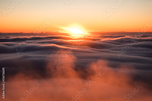 Winter landscape in Krkonose  beautiful sunrise with moon above the heavy clouds  shot from highest mountain in Czech republic called Snezka.