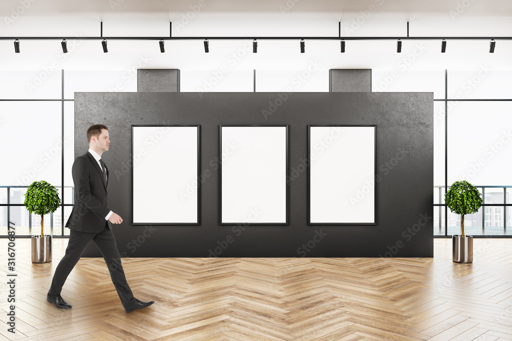 Businessman walking in contemporary gallery interior Businessman walking in contemporary gallery interior