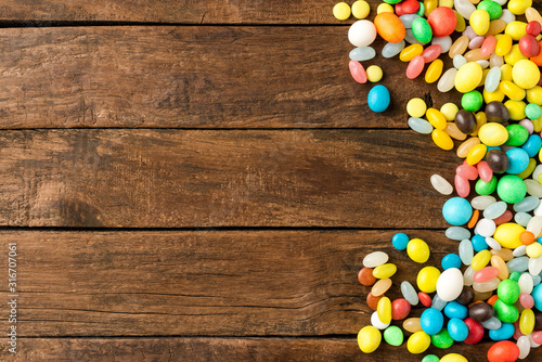 Colourful sweets on wooden table with copyspace. Top view