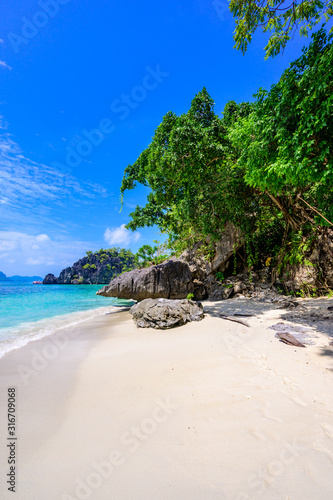 Tropical Papaya beach at paradise coast, El Nido, Palawan, Philippines. Tour A Route. Coral reef and sharp limestone cliffs.