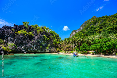 Tropical Papaya beach at paradise coast, El Nido, Palawan, Philippines. Tour A Route. Coral reef and sharp limestone cliffs.