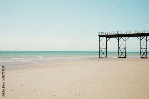 Pier stands on beach at low tide