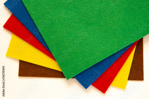 Fan of colored bright felt textile material. Brown, red,orange,purple, grey, yellow and pink color composition. Colorful felt texture for background with copy space. Felt fabric sheets