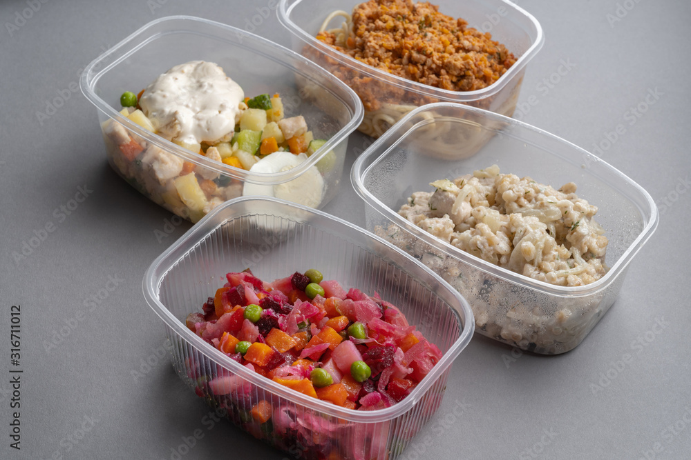 4 lettuce in molds for fast delivery. Pasta with minced meat and onion in navy-style and a jar of vinaigrette on a gray background. 4 lettuce in molds for fast delivery. Pasta with minced meat and onion in navy-style and a jar of vinaigrette on a gray background.