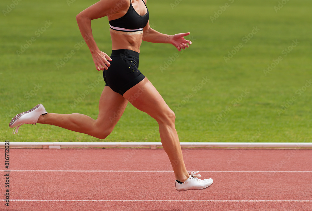 Female athlete running on stadium track, dynamic run of sprinter in a stadium