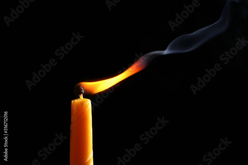 candle flame blow by air stream isolated on black background with copy space for your text