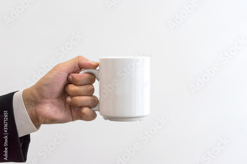 Businessman hold white mug.